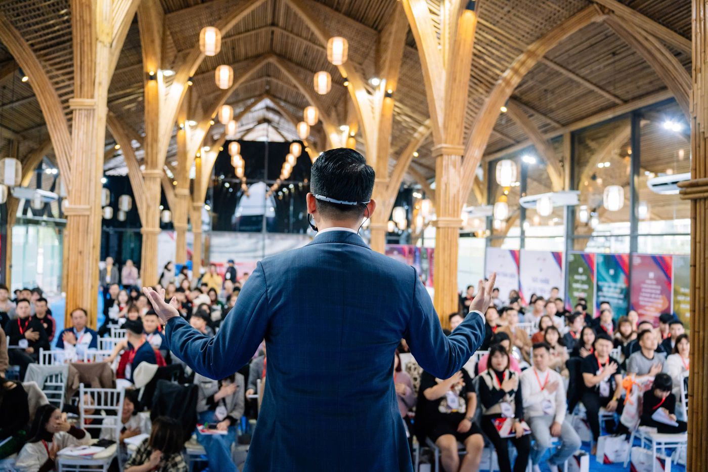 Cương trước hội trường đông kín. Anh viết: "Tôi không thuyết phục bằng lý lẽ. Tôi thắp lửa cho người ta tự đi." AI Agent là cách để họ đi được khi anh không ở đó.